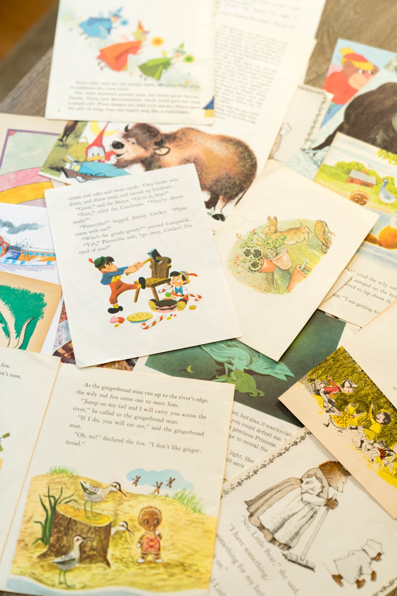 Vintage children’s book pages with colorful illustrations styled on a wooden background alongside stacked books and rustic props. Pinocchio by Disney